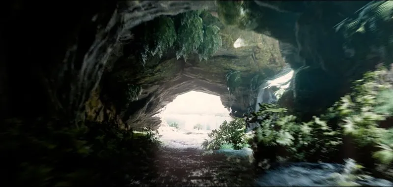 A cave mouth opens onto a jungle