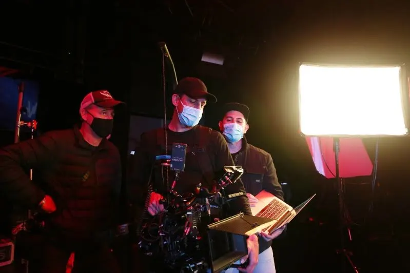 Crew around the camera rig with a laptop